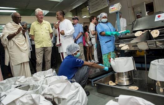 2.	Clinton being briefed on the Roti making process 