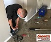 Masked Technician Repairing Carpeting in Westminster Home