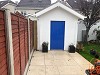 charming garden shed with blue door and paved frontage